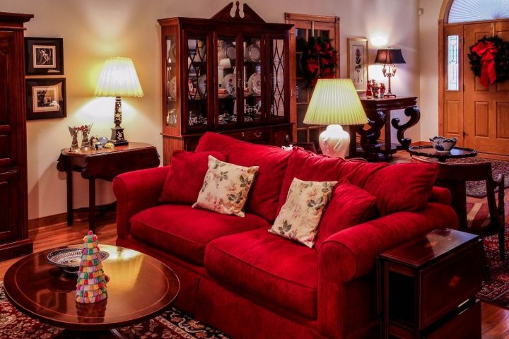 Гостиная с диваном и коврами в красных тонах