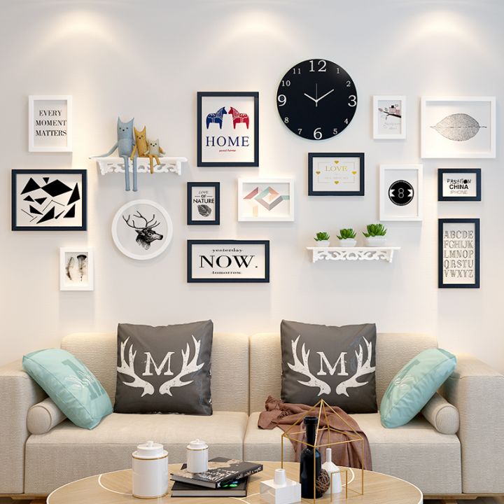 Композиция над диваном в гостиной из различных элементов: часы, картины, полочки