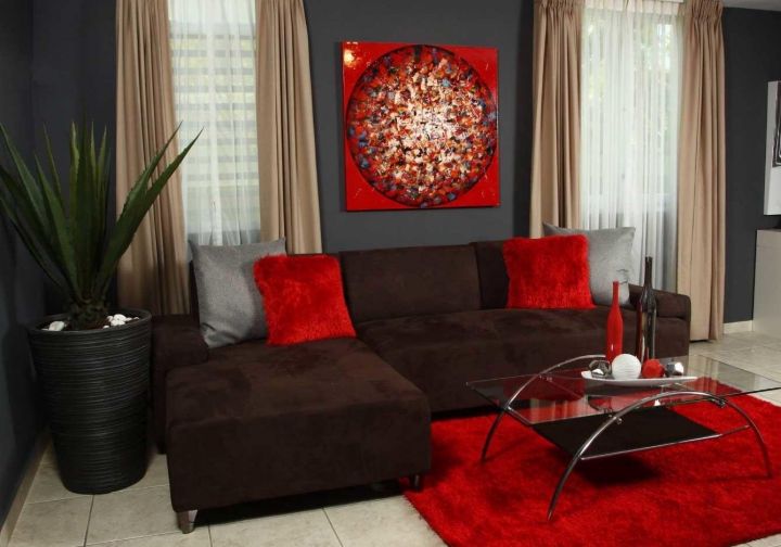 Темно-коричневая бархатная обивка, ярко-красный ковер и графитовые стены в гостиной