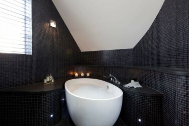 В больших ванных комнатах можно полностью оформить стены чёрным цветом